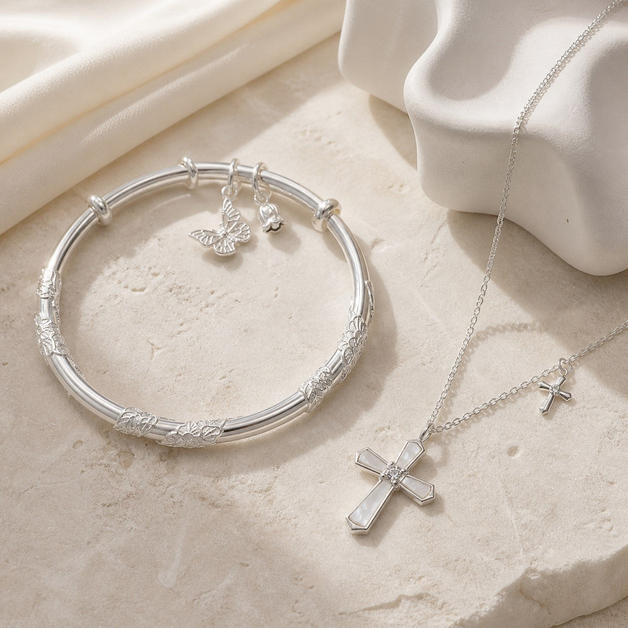 Fine silver jewelry arranged on pale stone